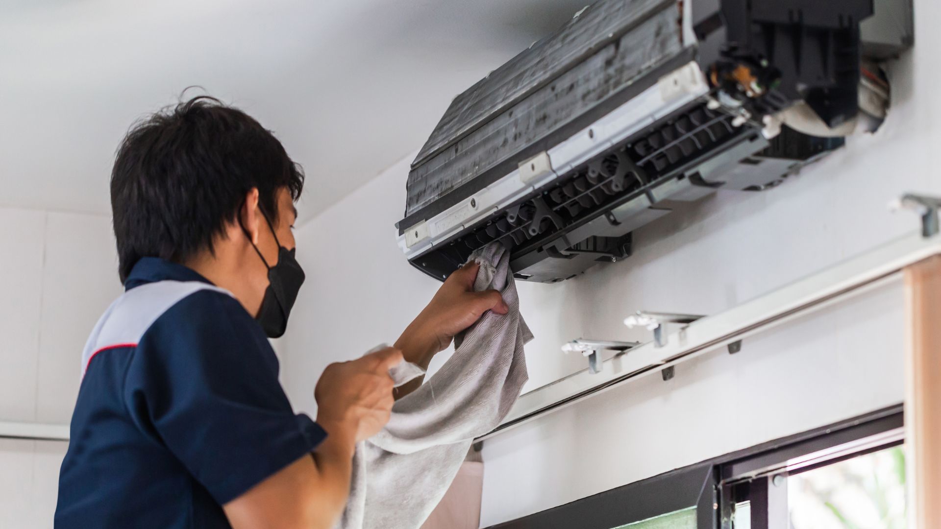 A man cleaning the aircon